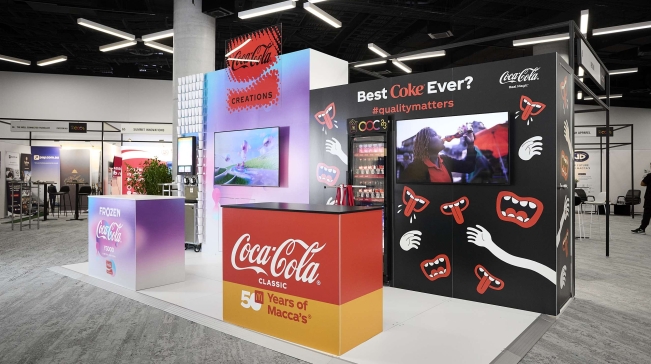 A display booth showcasing a Coca Cola vending machine, offering refreshing beverages to customers.
