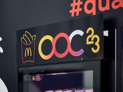 A Coca-Cola vending machine at a McDonald's conference with the words "OOC 23" on it.